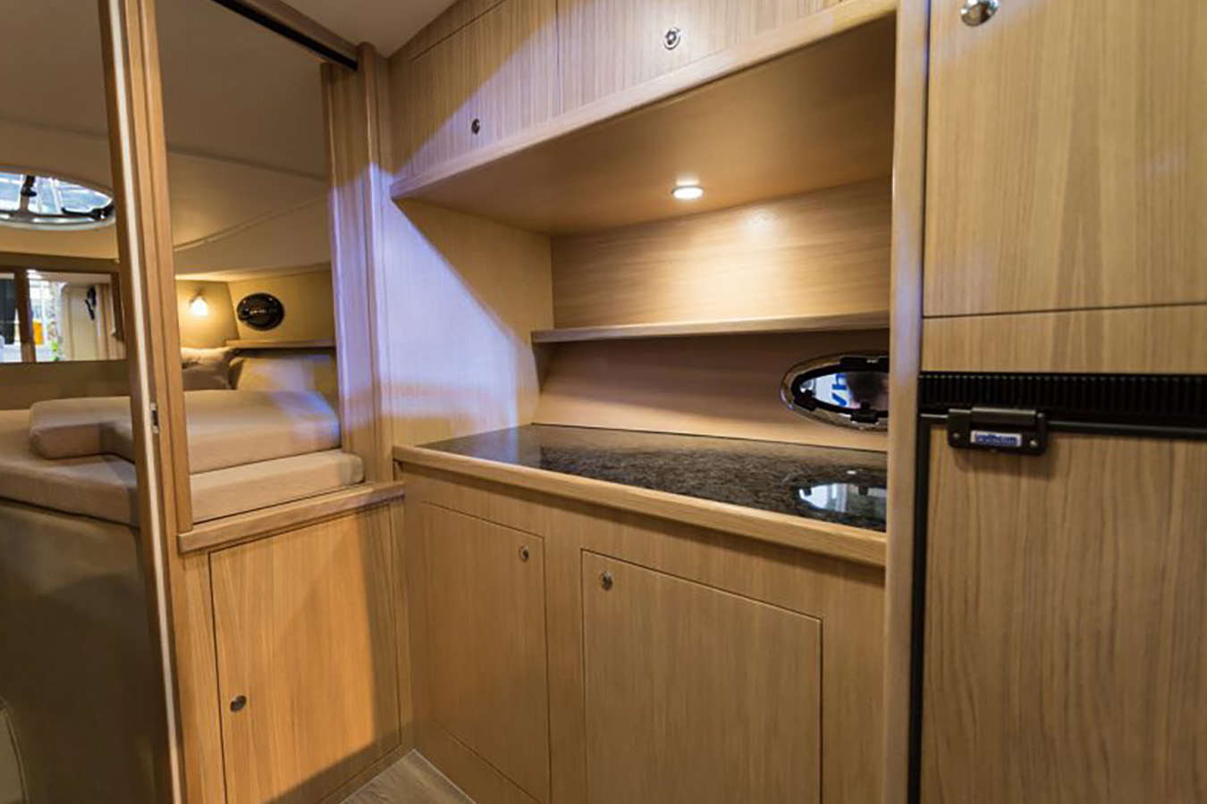 Kompaktna kuhinja plovila Mirakul 30 s radnom plohom i ormarićima spremnoj za najam iz Biograda