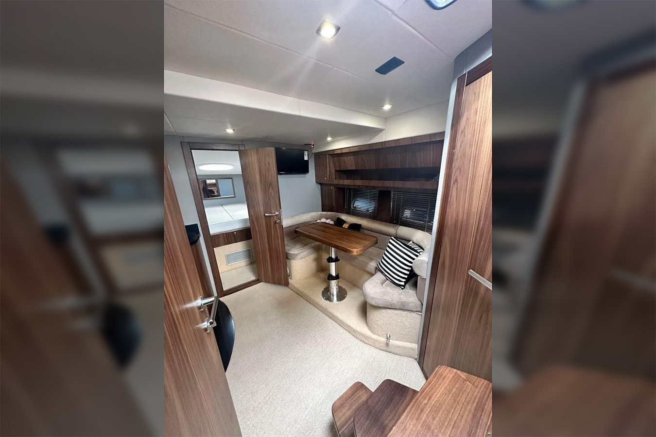 Prostrani salon s TV-om i ulazom u kabinu na jahti za najam