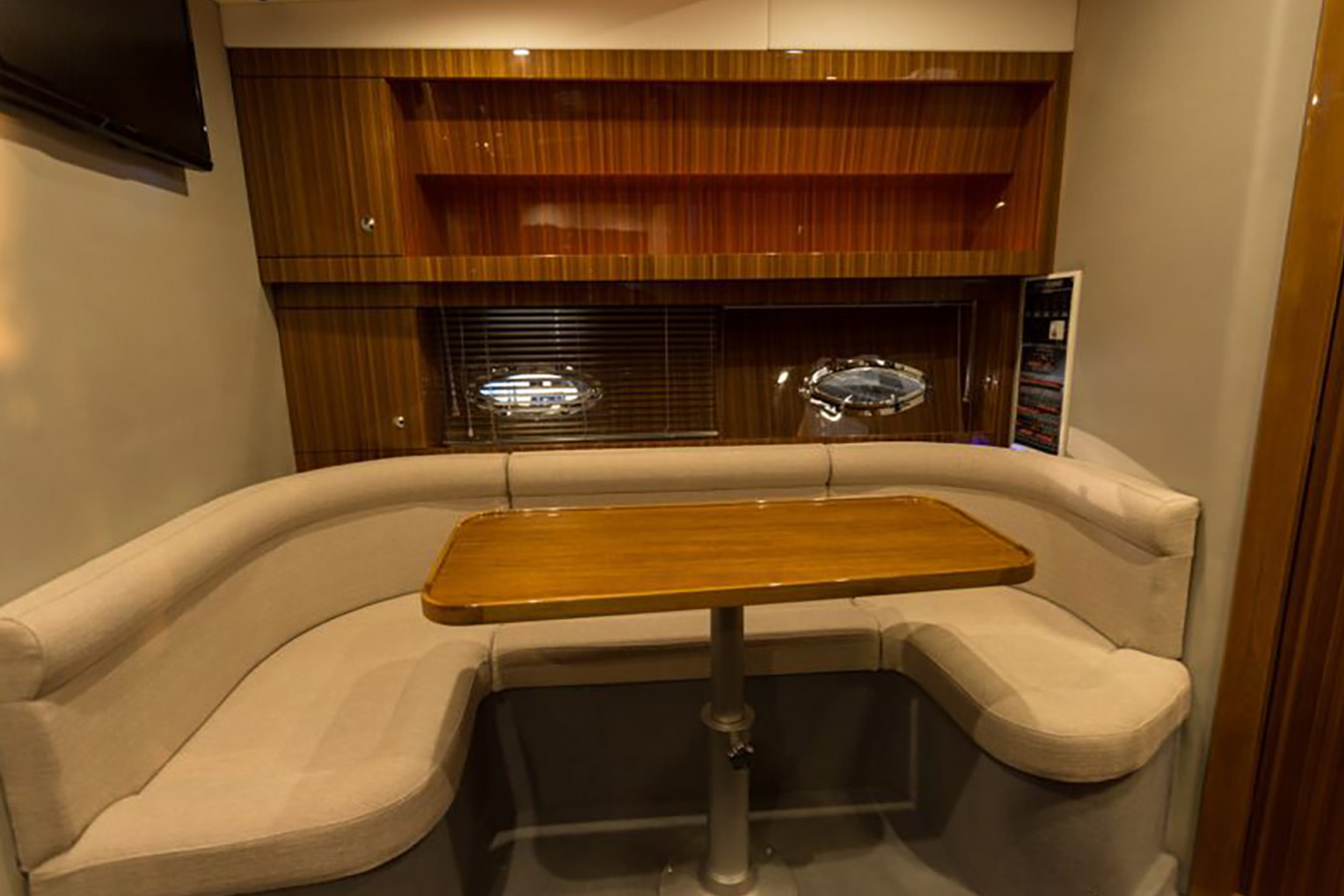 Unutarnji saloon Mirakul 40 s U-sjedalom i podiznim stolom, bočnim prozorima i policama od drveta — ugodan dnevni boravak luksuzne jahte