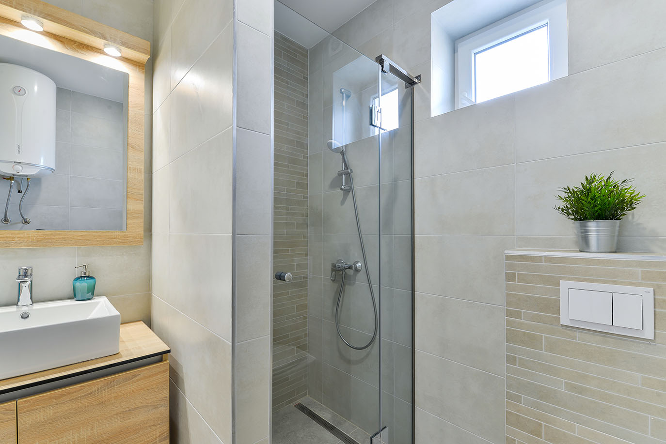 Moderna kupaonica s walk-in tušem, drvenim ormarićem i bijelim umivaonikom, dio luksuznog smještaja