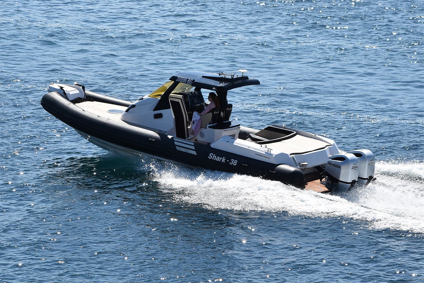 Crno-bijeli RIB Shark 38 s tvrdim krovom i dvostrukim Honda izvanbrodskim motorima 250 KS juri preko mirnog mora; demonstracija performansi i kvalitete domaće proizvodnje brodova