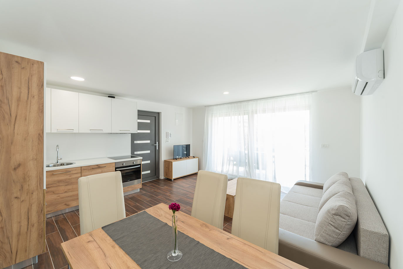 Svijetao i moderno uređen otvoreni prostor koji objedinjuje kuhinju, blagovaonicu i dnevni boravak, savršen za apartmani Vir