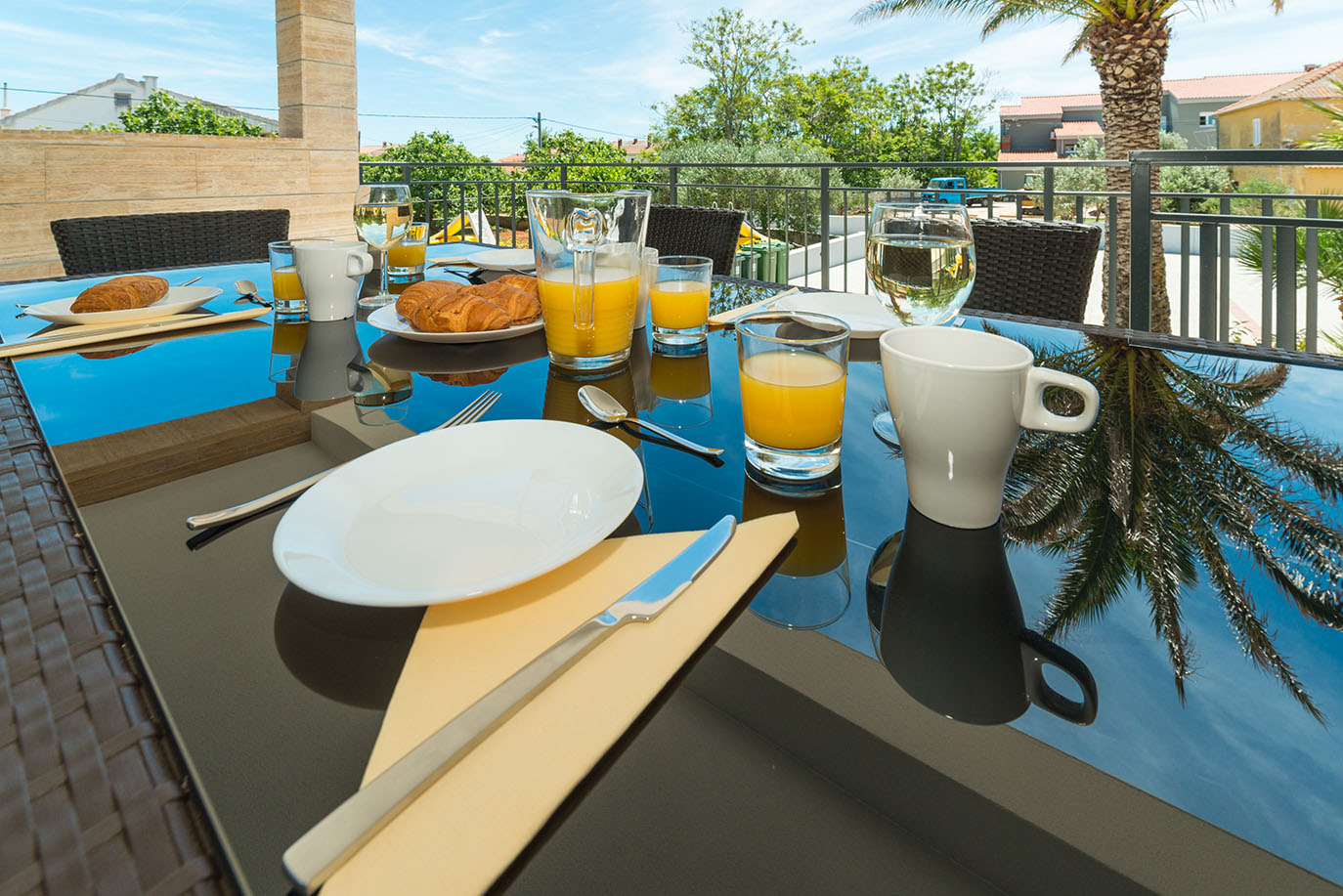 Obilan doručak na sunčanoj terasi s kroasanima, svježim sokom od naranče i kavom, savršen za goste apartmana Vir