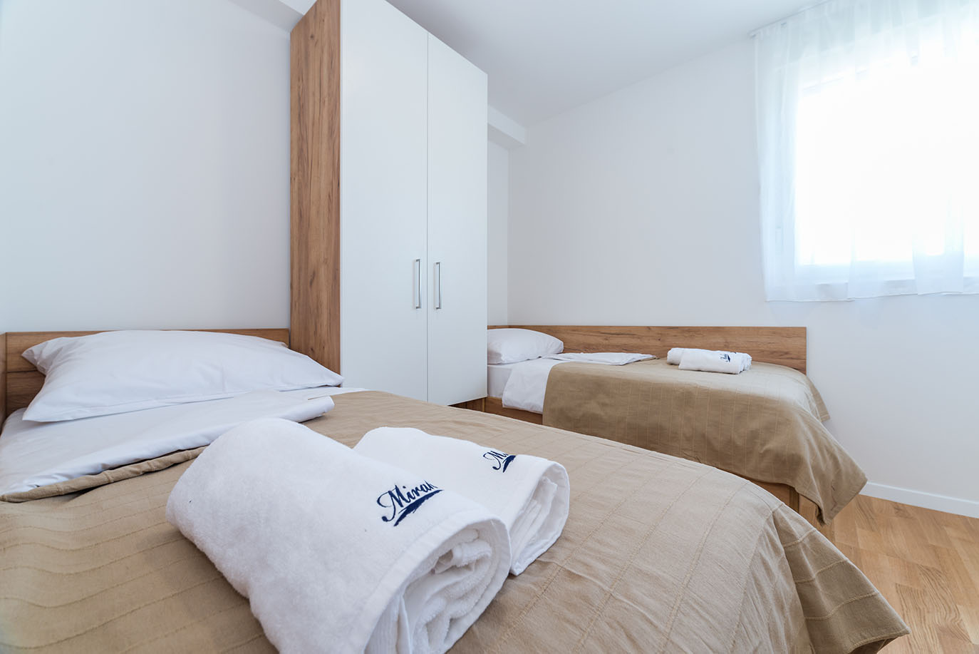Svjetla dvokrevetna spavaća soba u Villa Mirakul, s dva kreveta, svježom bijelom posteljinom, čistim ručnicima i modernim ormarom